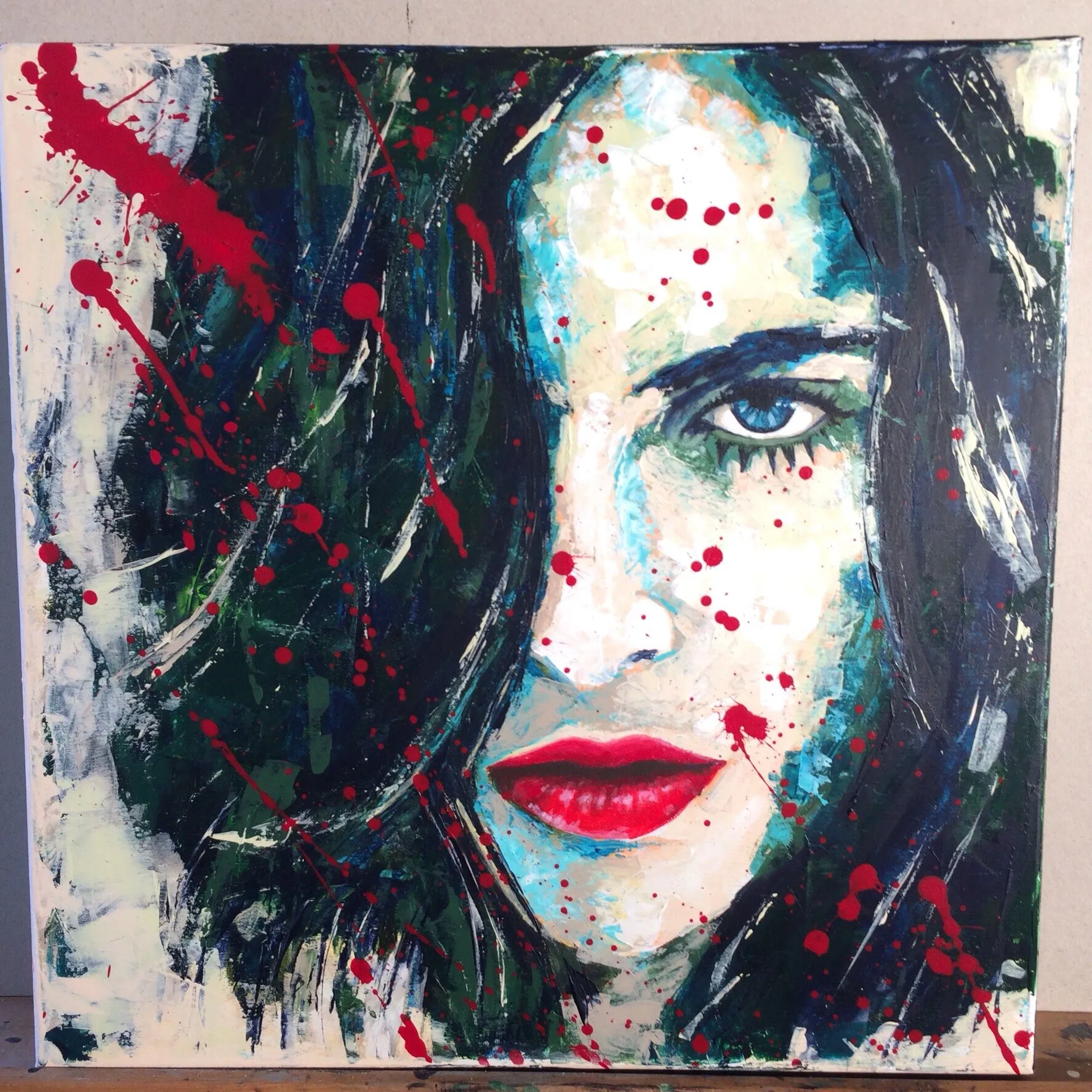 Portrait féminin acrylique au teint bleu-vert, lèvres rouges, éclaboussures de gouttes rouges